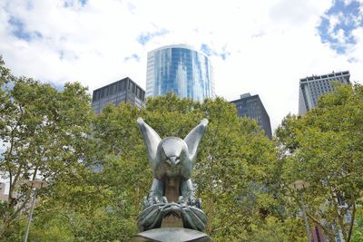 Low angle view of statue in city against sky