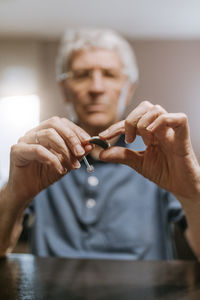 Senior man examining hearing aid