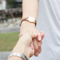 Cropped image of man holding woman hand