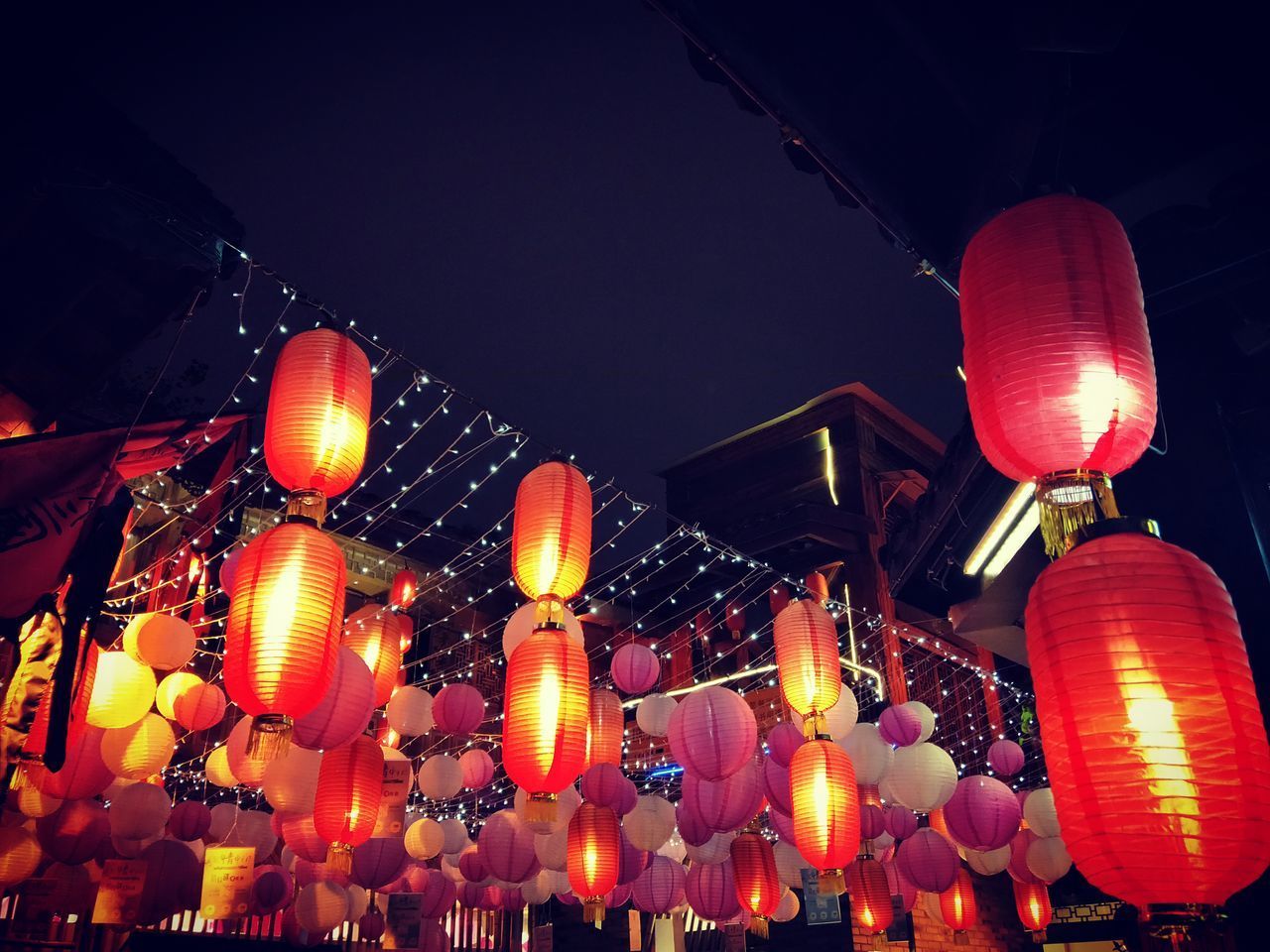 LOW ANGLE VIEW OF ILLUMINATED LANTERNS AGAINST SKY