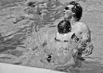 High angle view of father and son swimming in pool