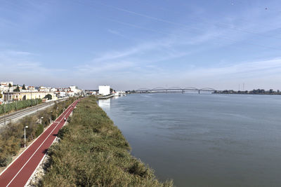 Bridge over river in city against sky