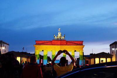 Illuminated rainbow flag on brandenburg gate against sky