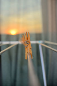 Close-up of clothespins on metal during sunset