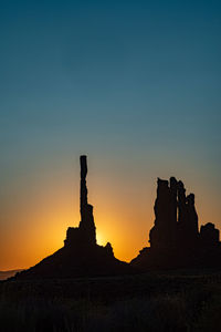 Silhouette rock formations against sky during sunset