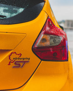 Close-up of yellow sign on car