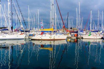 Boats moored in water against sky