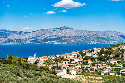 High angle view of townscape by sea against sky