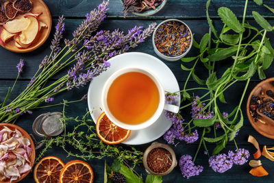 Tea. herbs, flowers and fruit around a cup of tea, an overhead flat lay shot