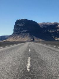 Road by mountain against clear sky