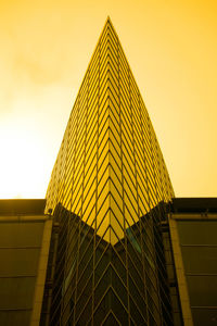 Low angle view of modern building against sky during sunset