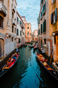 Typical venetian canal crowded with gondolas crossing it