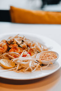 Thai traditional food pad thai noodles with shrimp, fresh sprouts and a slice of lemon. close up