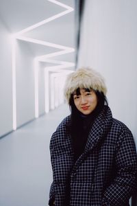 Portrait of teenage girl standing against wall