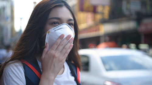 Woman wearing pollution mask in city