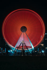 Low angle view of illuminated ferris wheel against sky at night