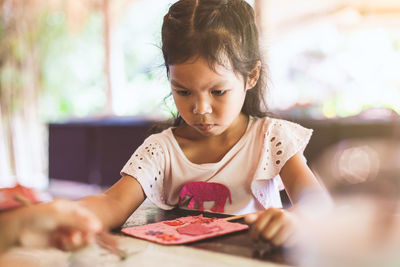 Girl looking away while holding ice cream