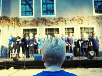 Rear view of boy looking at choir performance