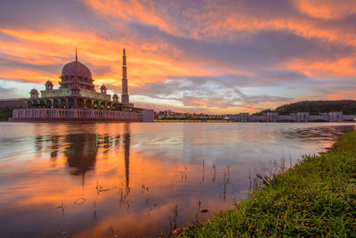 Scenic view of lake against cloudy sky during sunset