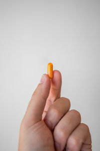 Close-up of hand holding paper over white background