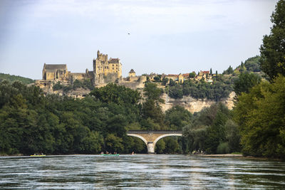 Arch bridge over river against buildings