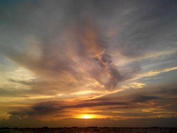 Scenic view of sea against cloudy sky at sunset