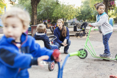 Angry teacher with children playing on playground