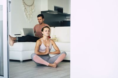 Portrait of young couple sitting on wall