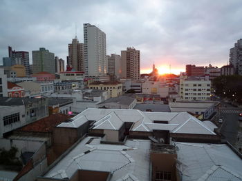 Buildings in city against sky during sunset