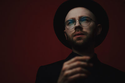 Portrait of young man against black background