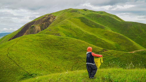 Woman standing on mountain against sky