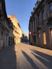 Street amidst buildings against clear sky