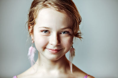 Portrait of a young girl with festive makeup for a party. earrings-feathers in the ears