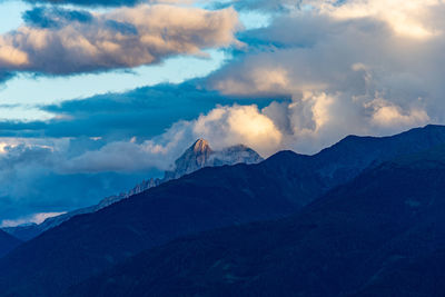 Scenic view of mountain range against cloudy sky