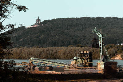 Traditional windmill by trees against clear sky