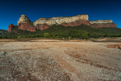 Rock formations on landscape against blue sky