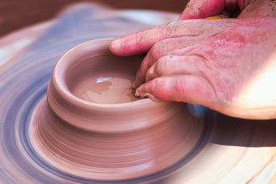 Cropped hand of person making pottery at workshop