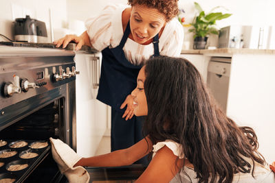 Side view of young woman standing at home