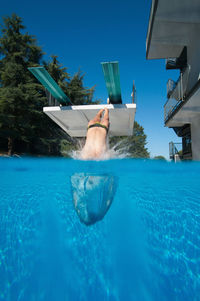 Low section of man swimming in pool