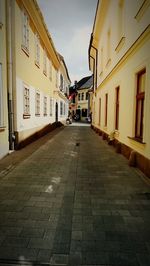 Empty alley amidst buildings in city