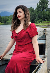 Portrait of young woman sitting on railing