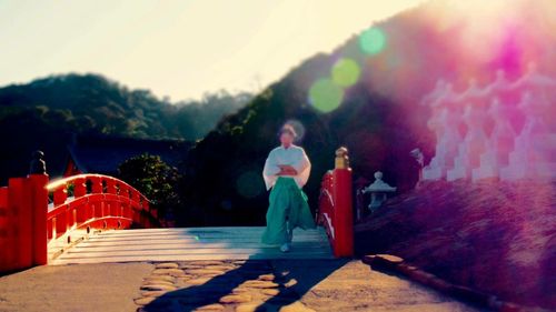 Full length of woman sitting on railing