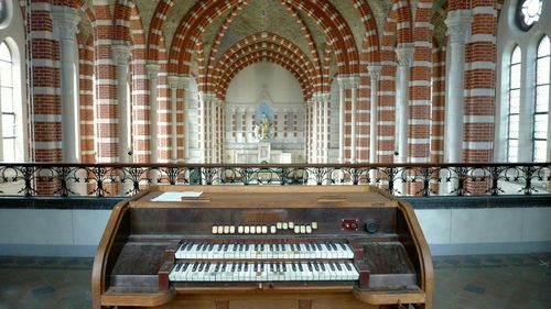 Pipe organ by railing in church
