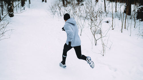 Man running on snow covered field