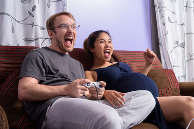 Excited couple playing game at home