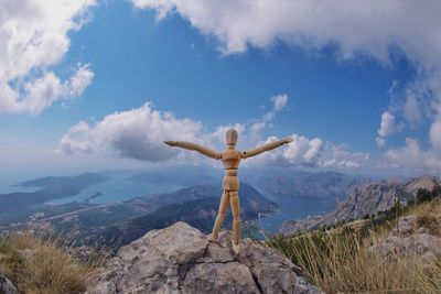 Low angle view of man standing on mountain against sky