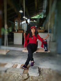 Full length portrait of young woman holding umbrella