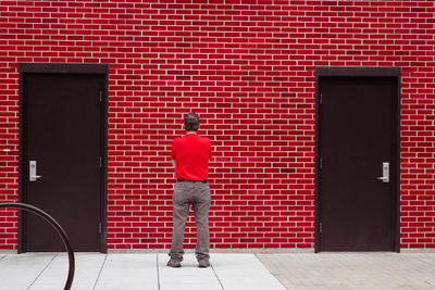 Rear view of man against brick wall