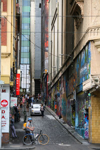 Vehicles on road by buildings in city