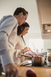 Couple preparing food in domestic kitchen